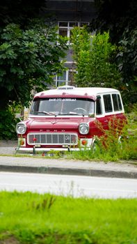 Classic red and white Ford van parked on a street in Samsun, surrounded by greenery.