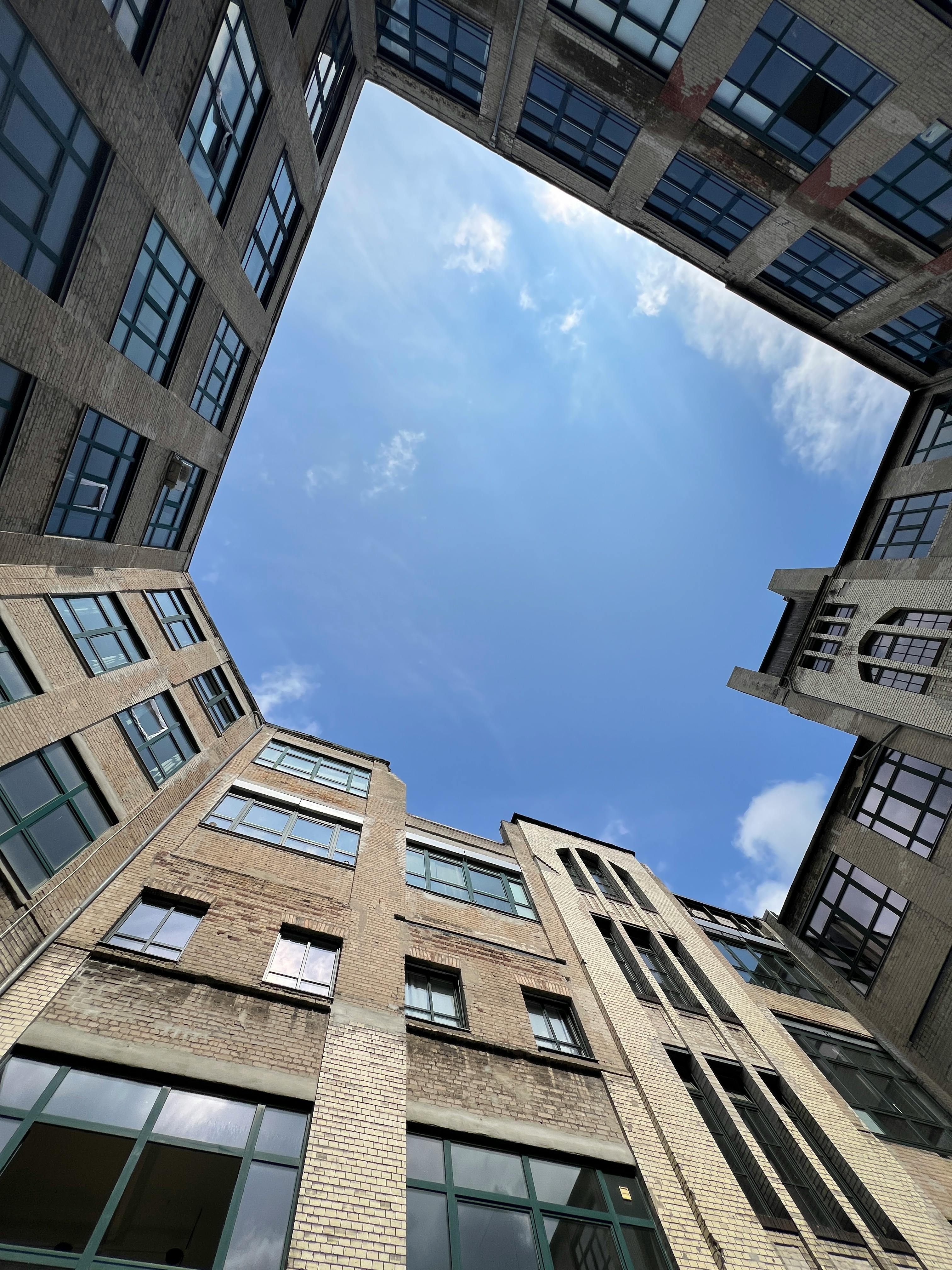 抬头仰望天空，城市庭院中矗立着高大的砖砌建筑