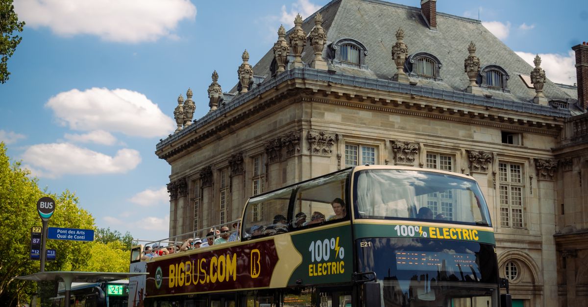Tour de France 2026 Guide: Routes, Dates, and Best Viewpoints 7 Double-decker electric bus in front of historic Parisian architecture.