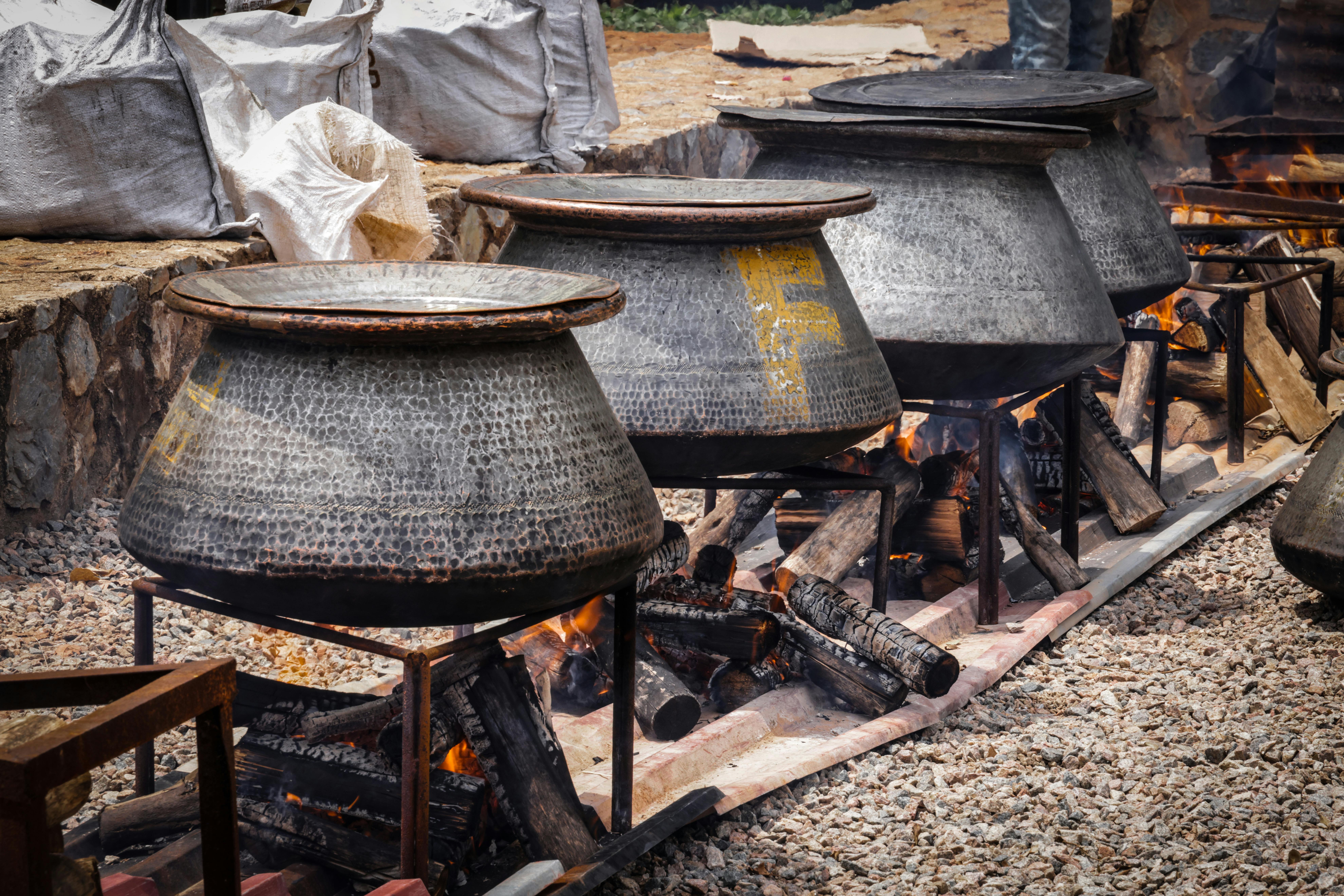 Christ Embassy volunteers cooking large pots of jollof rice in an outdoor kitchen in Ho, Ghana