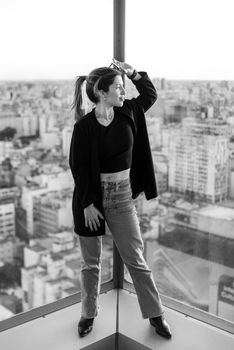 Elegant portrait of a woman standing on a rooftop overlooking Buenos Aires cityscape.