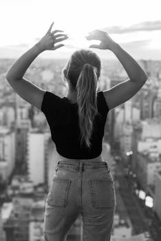 Black and white portrait of a stylish woman gazing over the Buenos Aires skyline.
