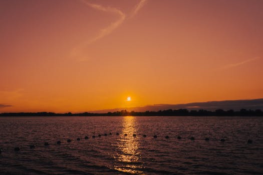 Stunning sunset over the Ottawa River with vivid orange hues reflecting on the water.