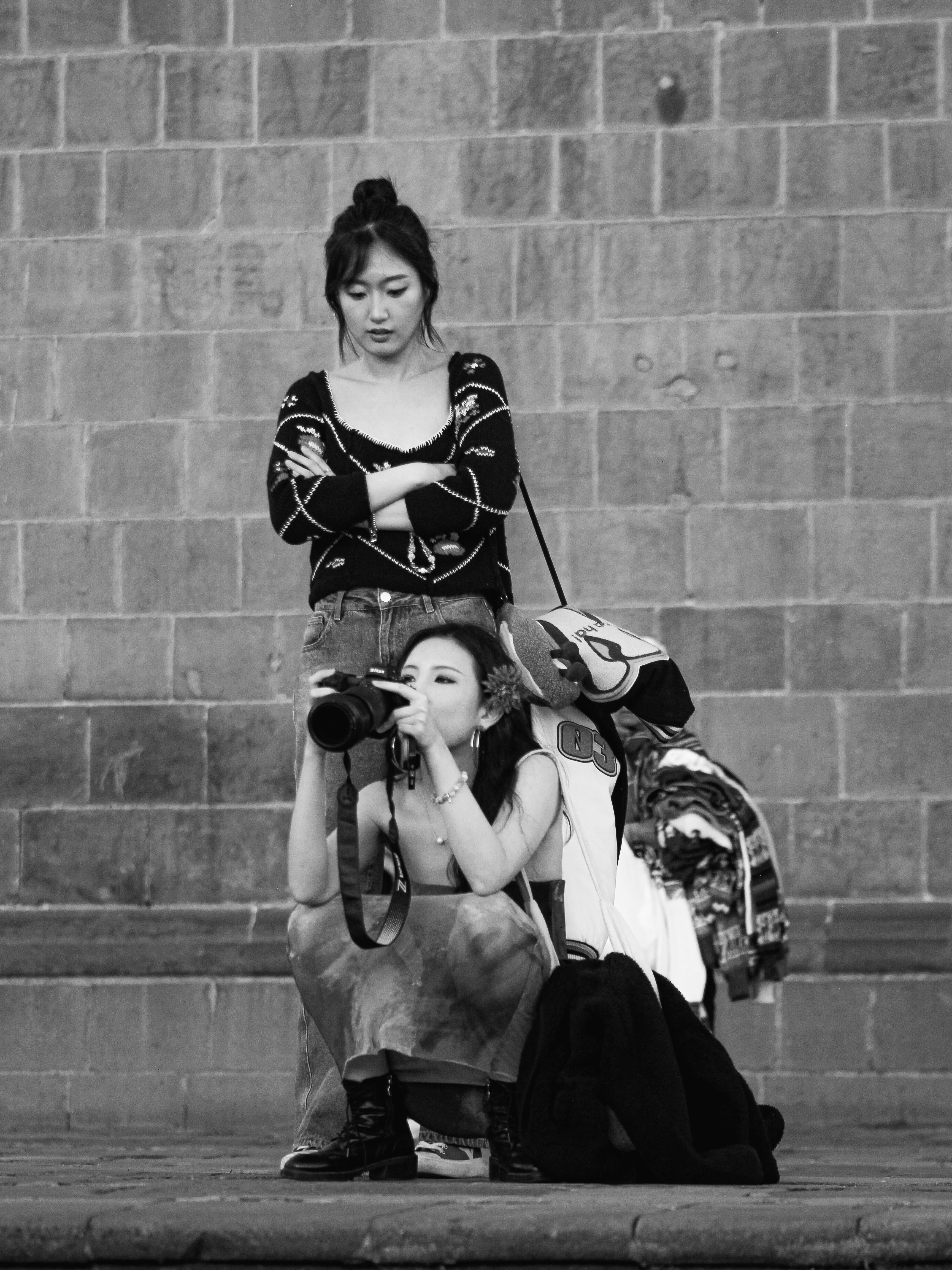 Two tourists capturing the essence of Cusco's historic architecture in a striking black-and-white photograph.