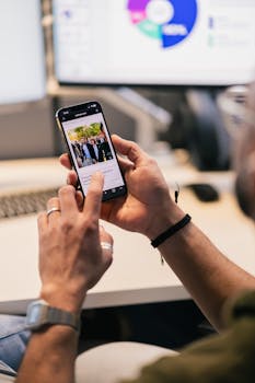 Close-up of individual using a smartphone in an office setting, showing productivity.
