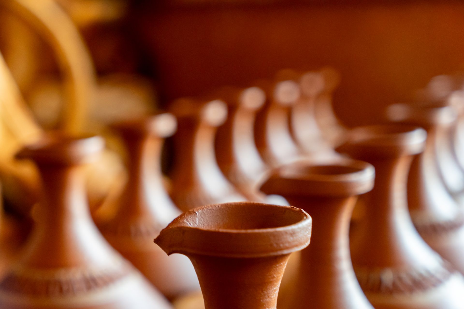 Explore the elegance of handcrafted clay pottery with this artistic close-up of traditional pieces.