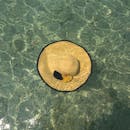 Floating Straw Hat on Clear Water Surface