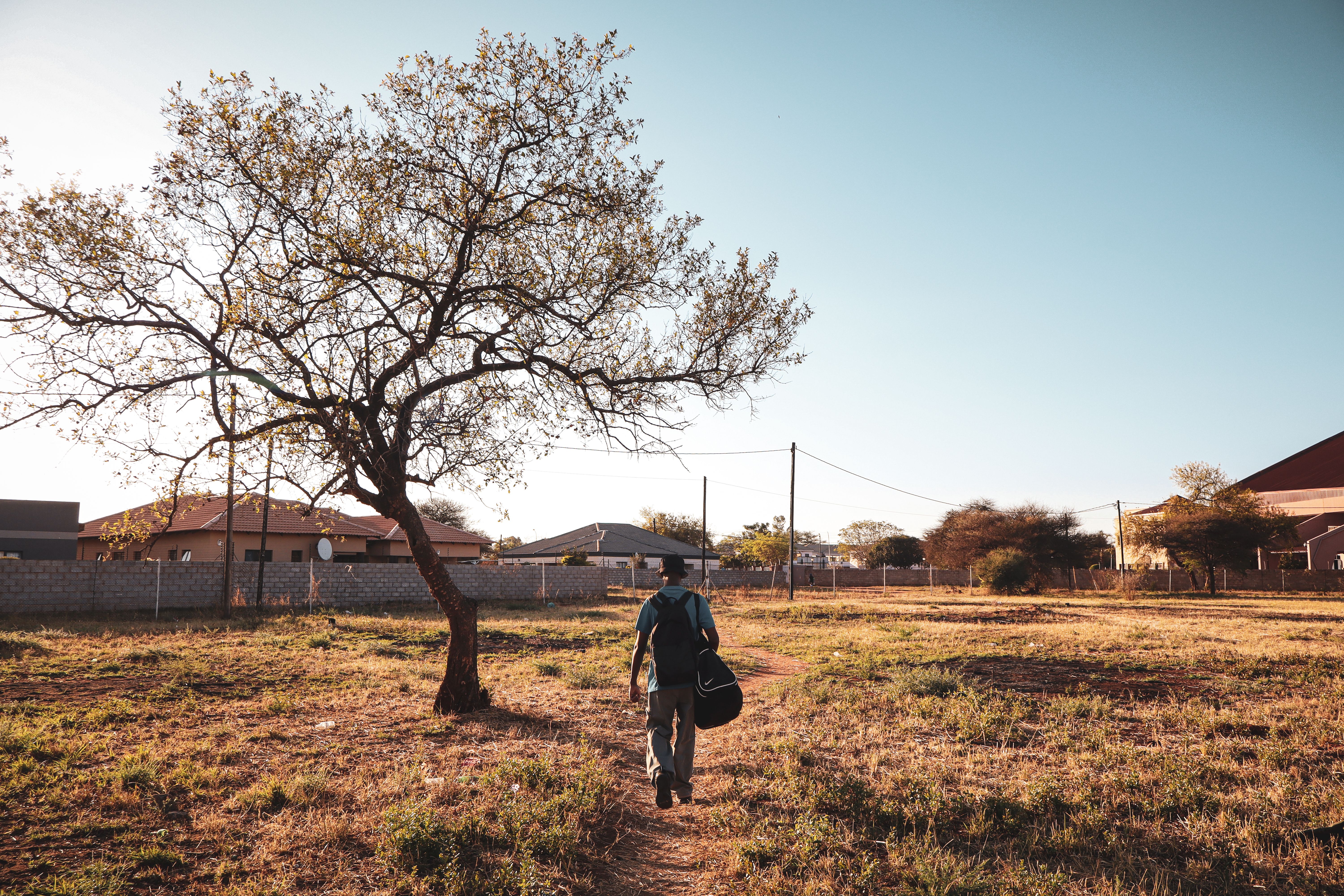 Lone Traveler Walking in Rural Landscape · Free Stock Photo