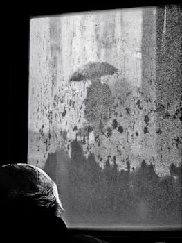 A silhouette with an umbrella seen through a rainy window in Istanbul.