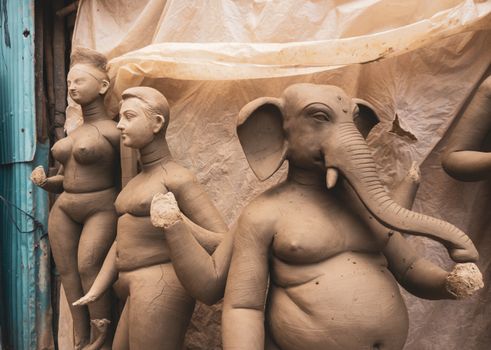 Clay sculptures of Hindu deities at an Indian workshop, showcasing traditional craftsmanship.