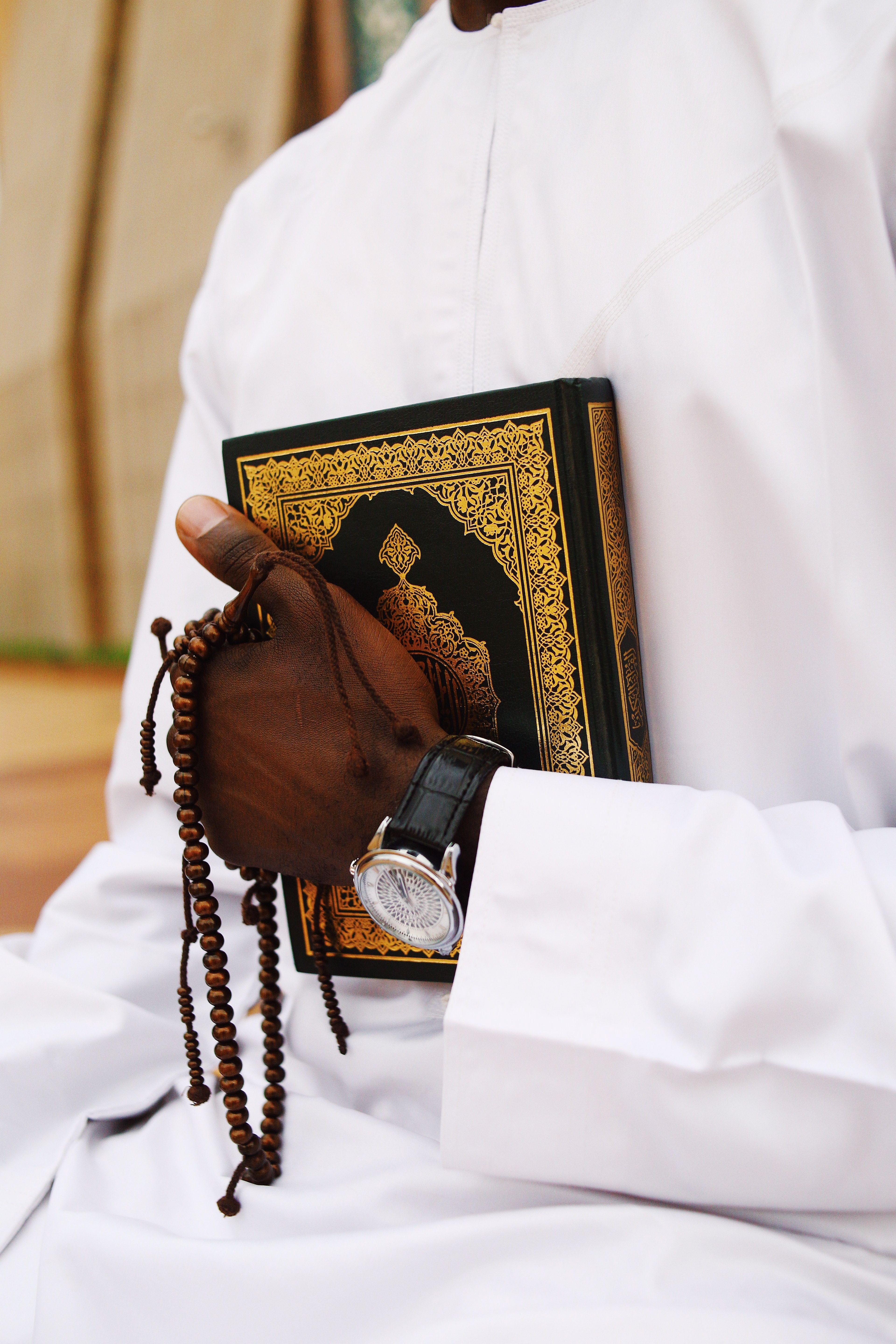 Man Holding Prayer Beads and Book with Red Bag · Free Stock Photo