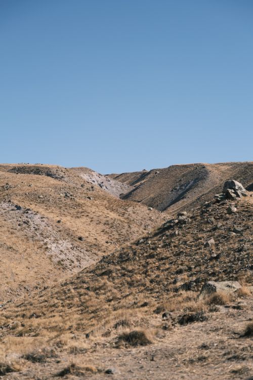 Free A serene landscape of rolling desert hills under a clear blue sky, showcasing natural beauty and tranquility. Stock Photo