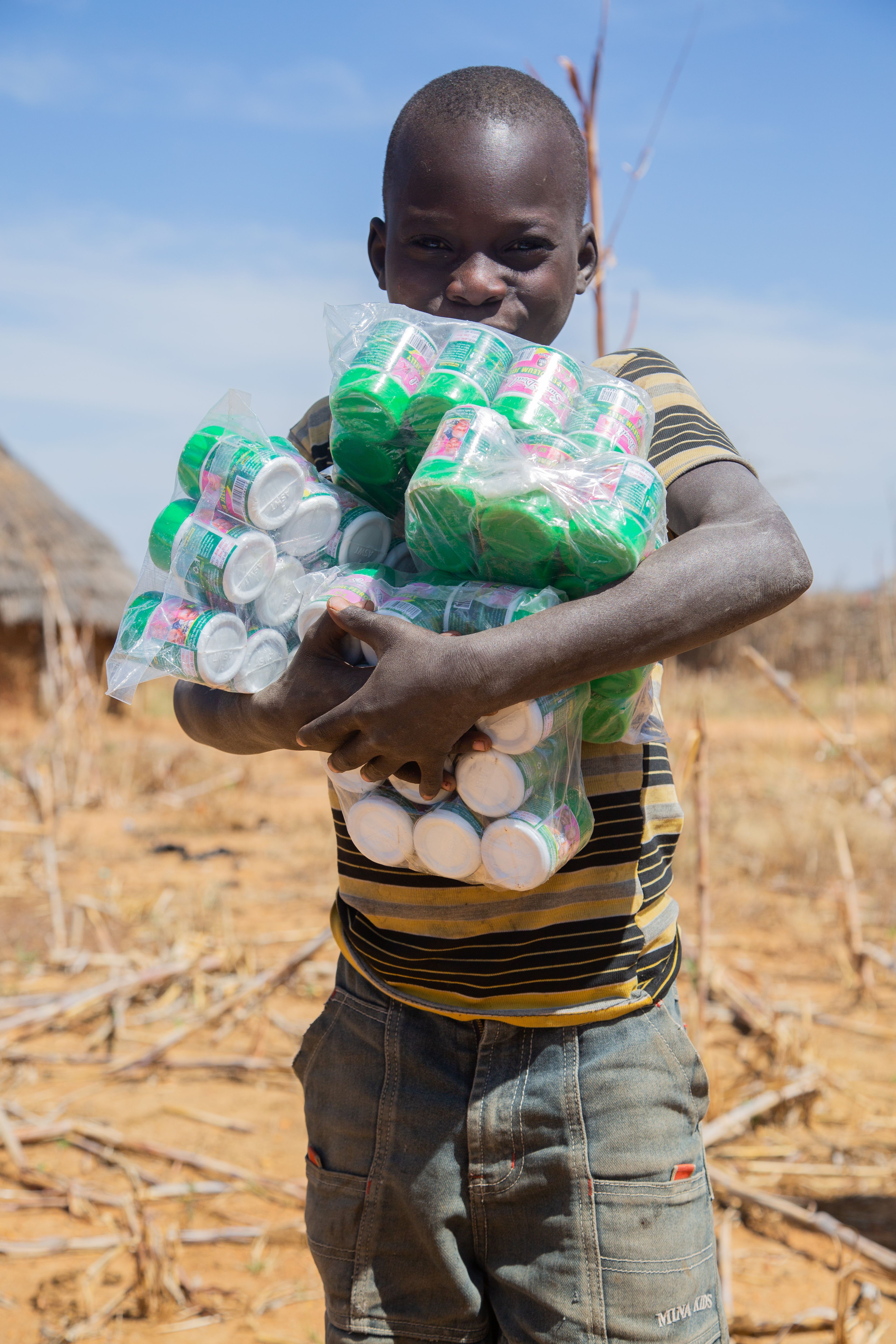 Young Boy Holding Packaged Milk in Rural Area · Free Stock Photo