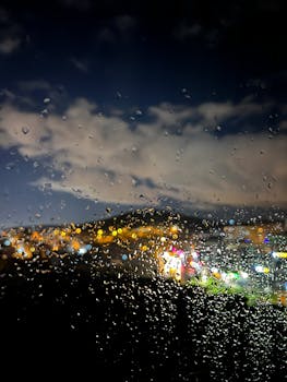 A rainy night window view with city lights glowing through droplets, capturing a poetic and serene atmosphere.