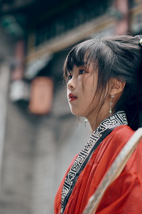Free Woman in red traditional attire captured in soft focus with heritage backdrop. Stock Photo