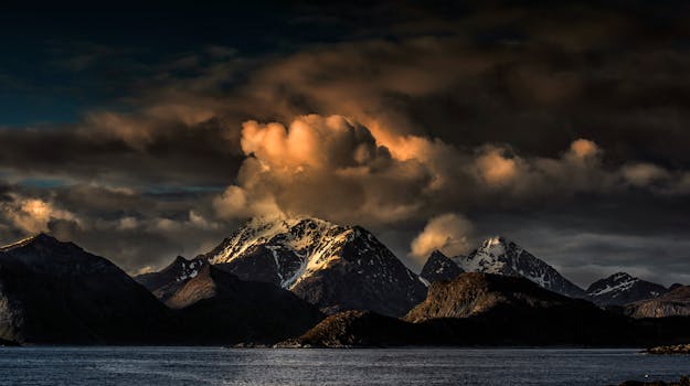 黄昏时分，白雪皑皑的山脉和戏剧性的云层令人惊叹