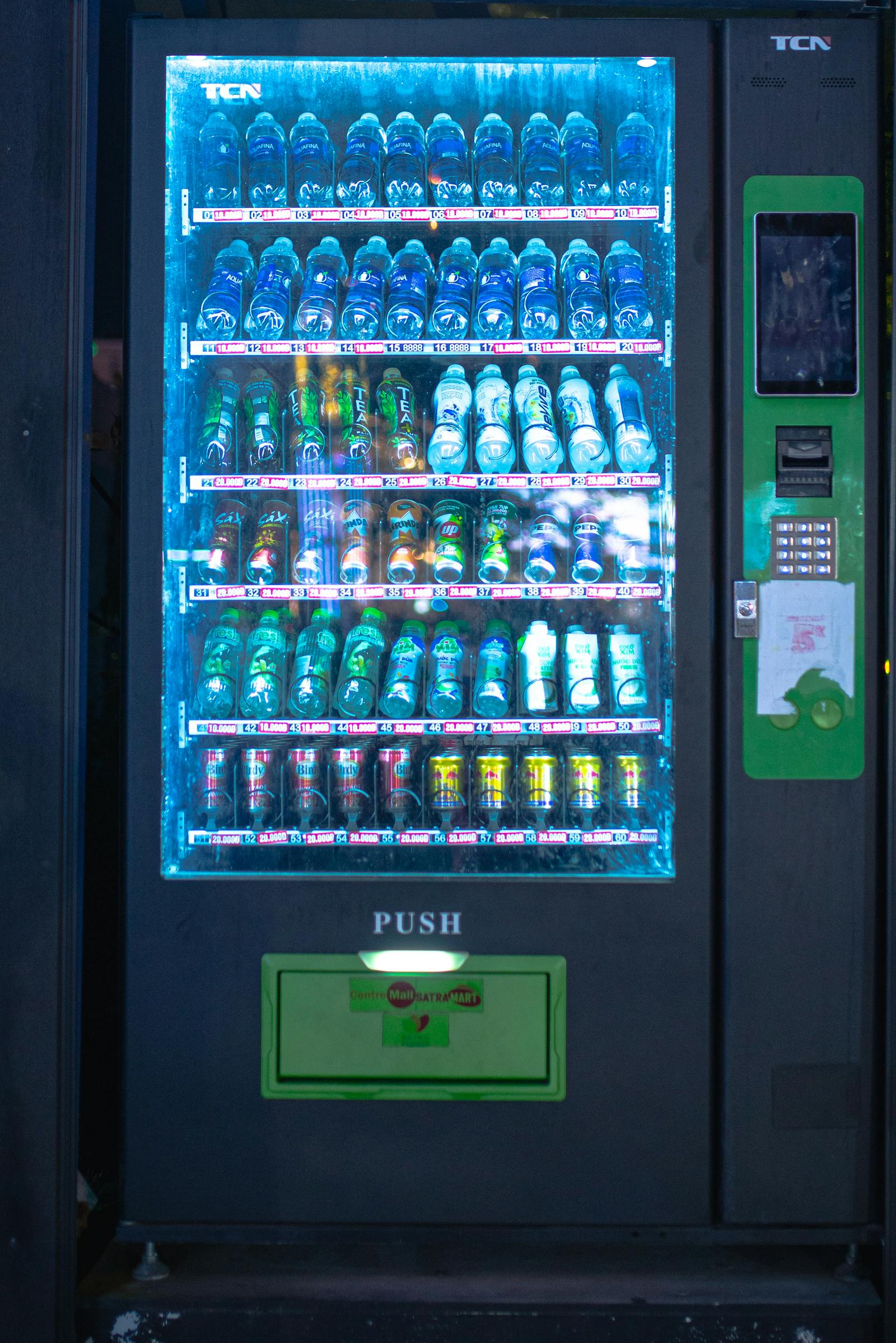 Illuminated vending machine at night with vibrant drinks display