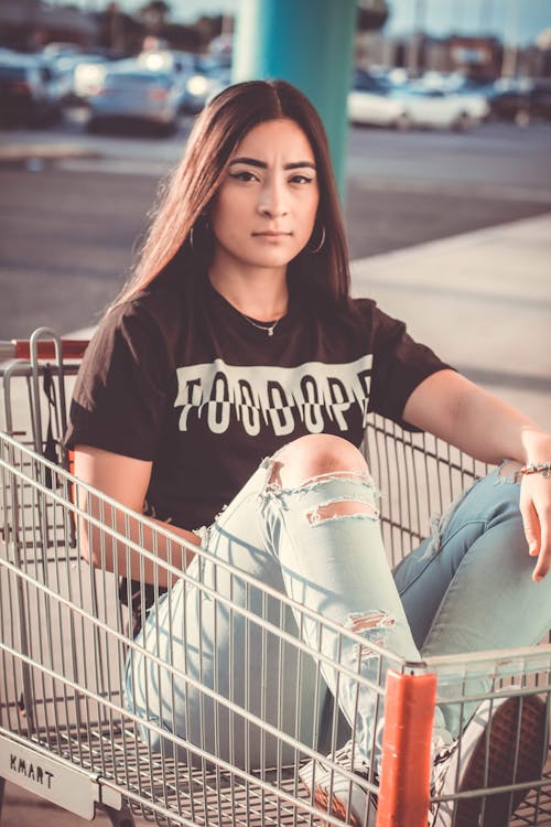 Woman Sitting Inside A Shopping Cart