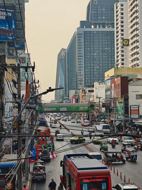 Free Vibrant Bangkok street scene with traffic, skyscrapers, and electric wires. Stock Photo