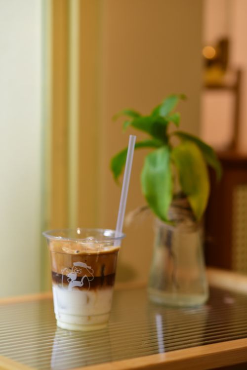 Free Refreshing iced coffee with a plant in a relaxing cafe atmosphere, ideal for lifestyle and comfort themes. Stock Photo