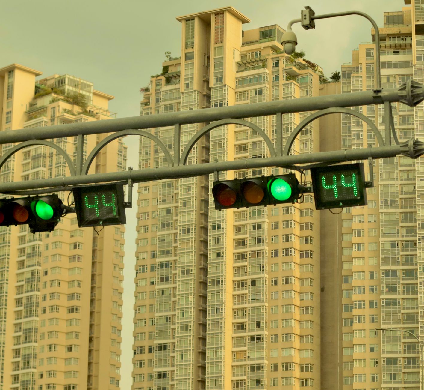 Green traffic lights with 44 seconds remaining against modern high-rise buildings.