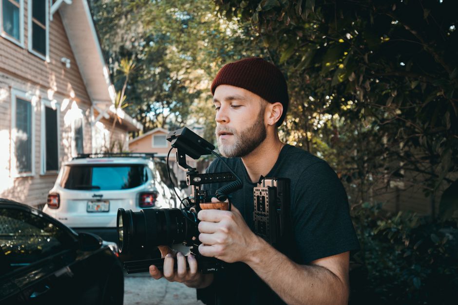 man recording video driveway
