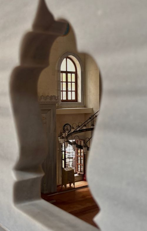 Free View of a vintage interior through an intricately carved window frame. Stock Photo