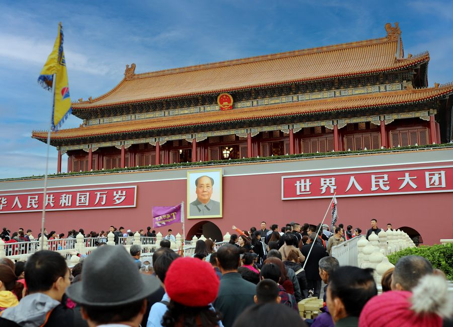 A large crowd gathers at the historic Tiananmen Gate in Beijing, China, showcasing Chinese architecture and culture.