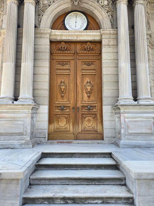 Free Detailed wooden door surrounded by classical columns in Türkiye. Stock Photo