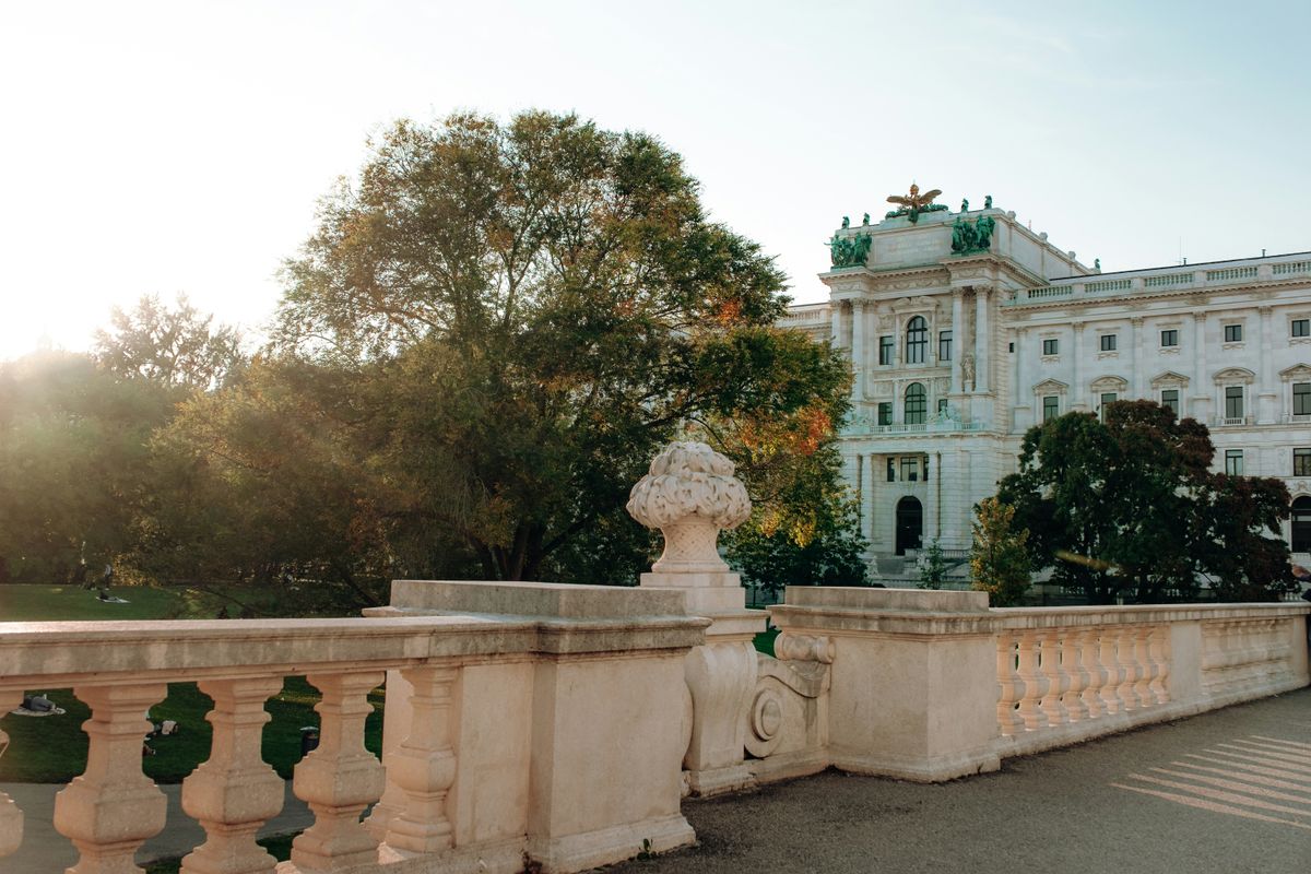 Palatul Hofburg din Viena într-o zi însorită, cu vegetație în prim-plan
