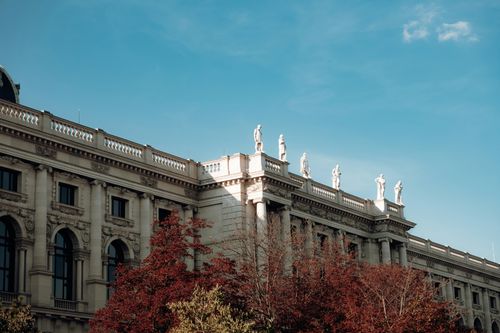 Free Elegant Vienna architecture with classical statues under a clear blue sky. Stock Photo