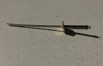 Miniature Katana Sword Keychain on Textured Surface