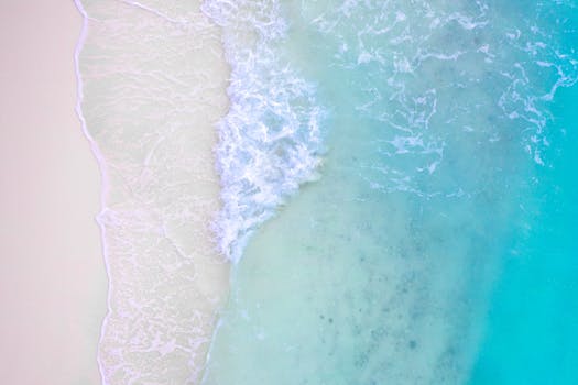 从空中俯瞰，绿松石般的海面上波浪涟漪，与沙滩相遇，营造出宁静的氛围