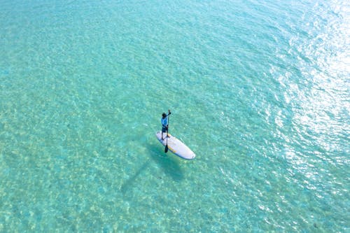 бесплатная Фотография человека, едущего на белой доске для серфинга Стоковое фото