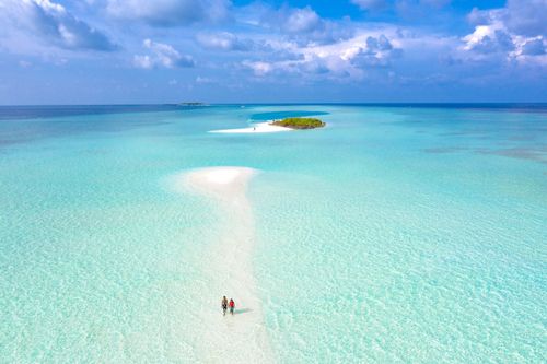 Free Aerial view of a tropical sandbar with turquoise waters and a clear sky, perfect for a serene vacation. Stock Photo