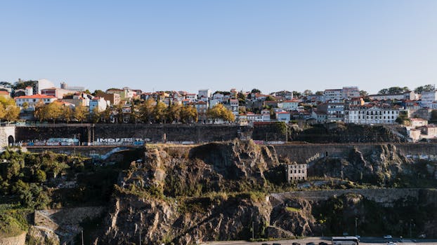 Captivating aerial shot of Porto’s cliffs with urban landscape, capturing vibrant color contrasts and architectural diversity.