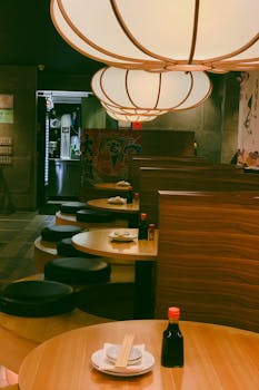 Warm lighting and wooden booths set the ambiance in a traditional Japanese restaurant.