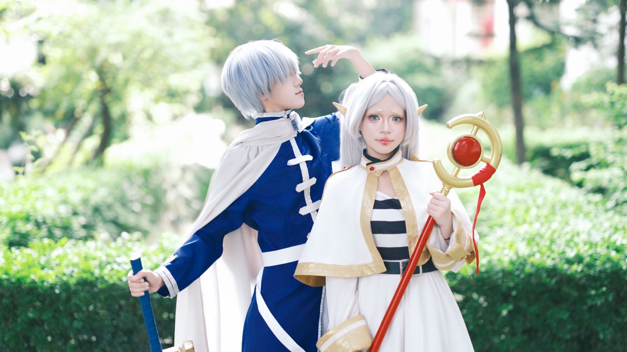 cosplayers dressed in fantasy costumes with props pose outdoors in a w