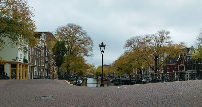 Picturesque view of an Amsterdam canal surrounded by autumn trees.