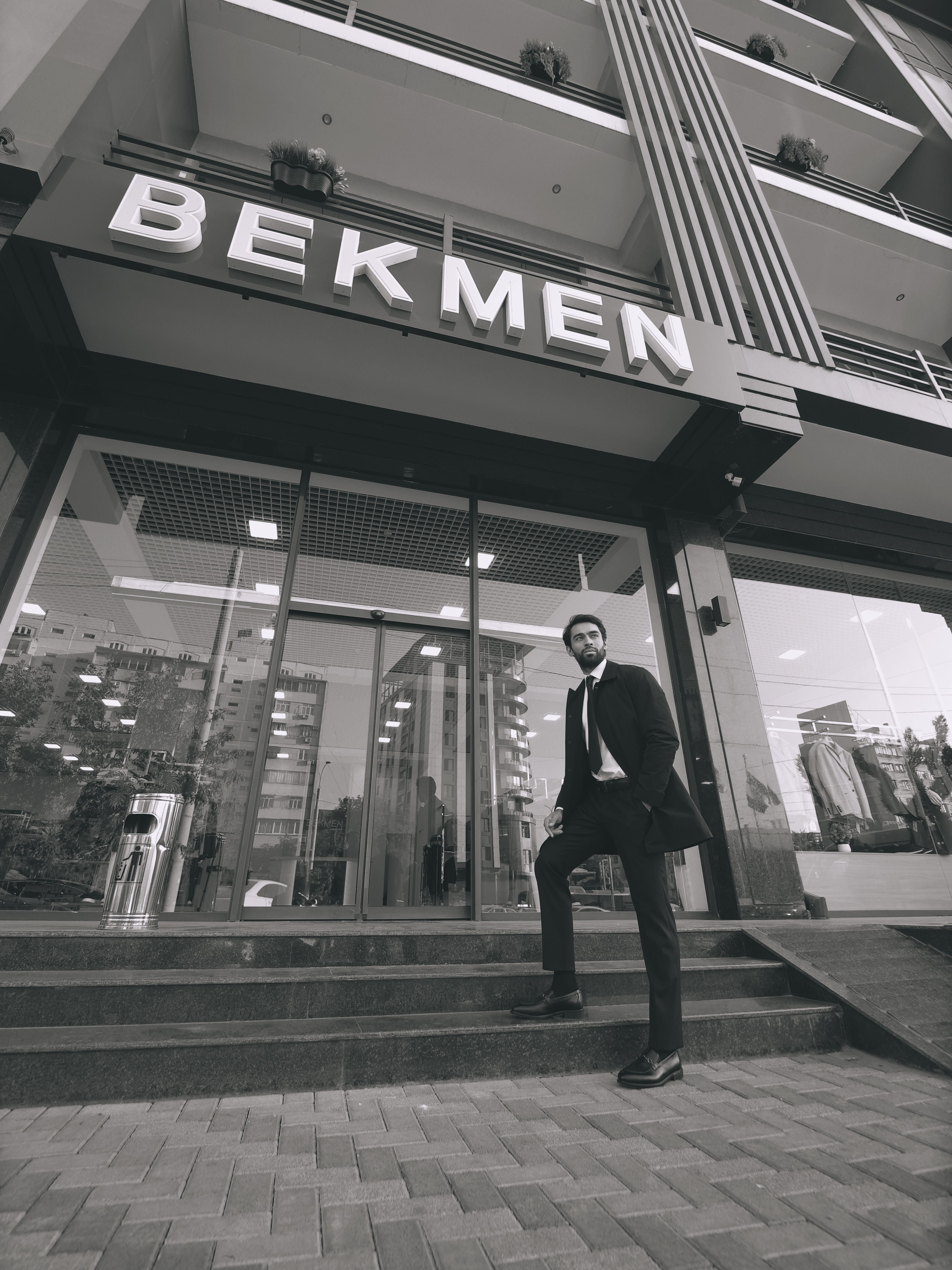 Confident businessman posing outside a modern building in urban environment.