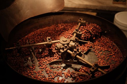Free Detailed view of coffee beans roasting in an industrial roaster, showcasing the roasting process. Stock Photo