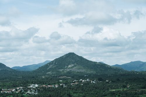 Free Lush green hills under a cloudy sky in Bengaluru, India, showcasing natural beauty. Stock Photo