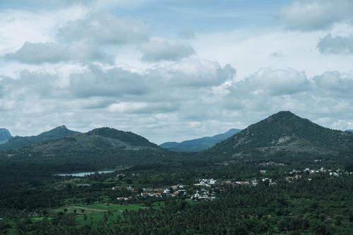 Free Capture of rolling hills and lush landscapes near Bengaluru, India under dramatic clouds. Stock Photo