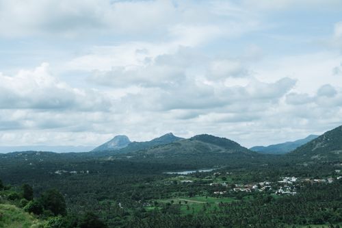 Free Explore the serene and lush hills of Karnataka, India, surrounded by dramatic clouds and vibrant greenery. Stock Photo