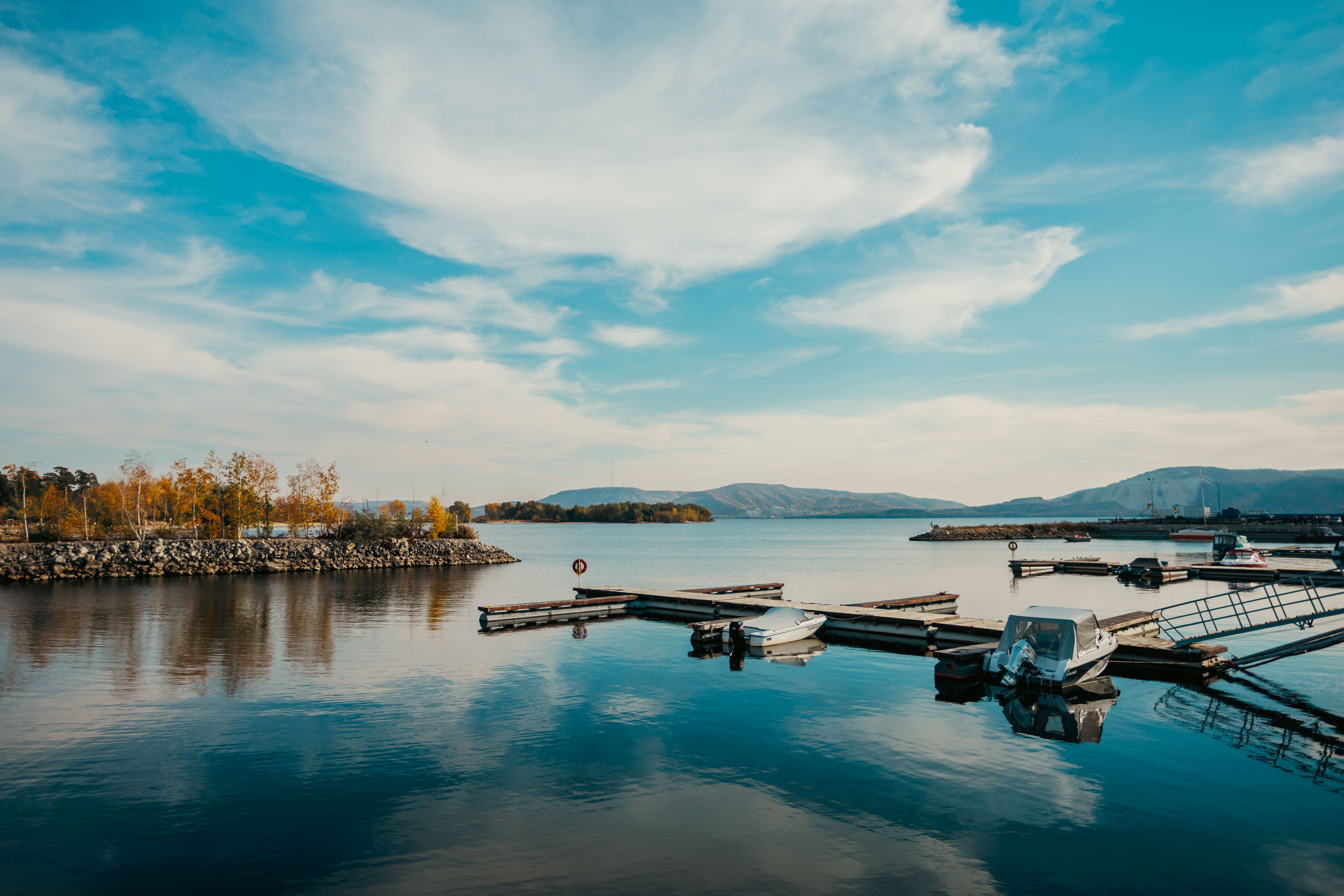 Tranquil lakeside marina scene with boats, calm water, and beautiful sky providing a peaceful escape.