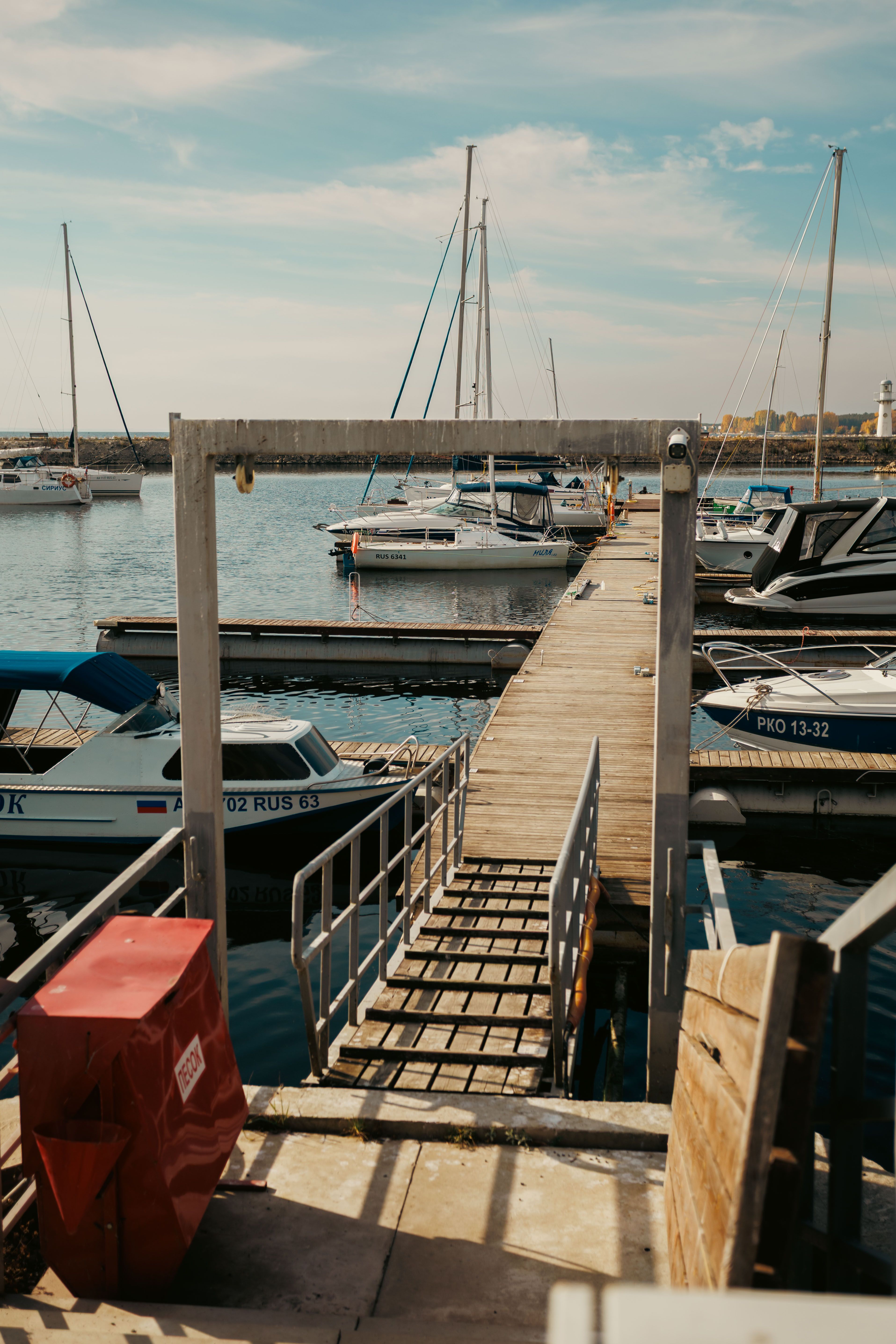 Tranquil marina with yachts, blue sky, and a wooden dock, perfect for travel and leisure themes.