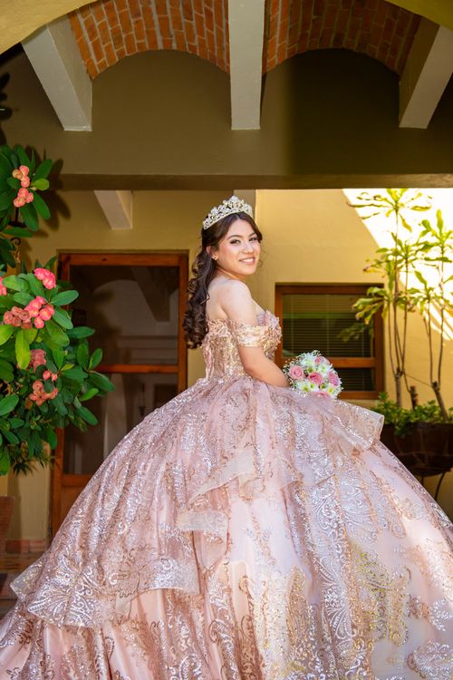 Free Young woman at her quinceañera in a stunning pink gown and tiara indoors. Stock Photo