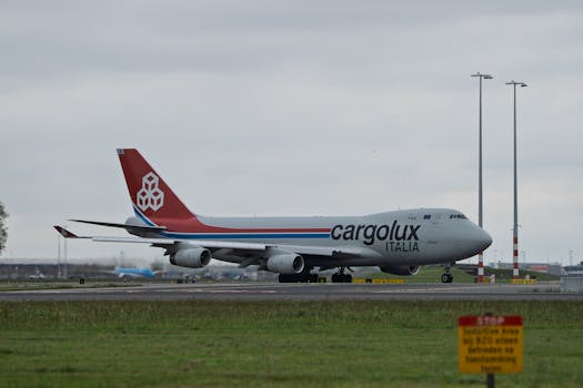 Cargolux Italia cargo plane taxiing on a runway at an airport with overcast skies.
