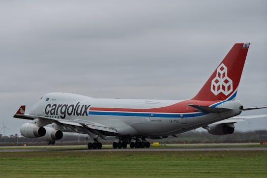 Cargolux cargo aircraft on runway preparing for takeoff on a cloudy day.
