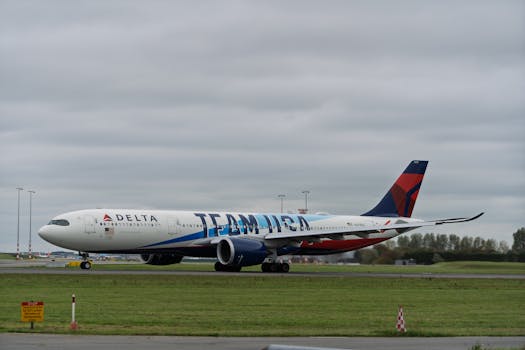 A Delta Airlines Airbus A330 with Team USA branding on a runway at an airport under cloudy skies.